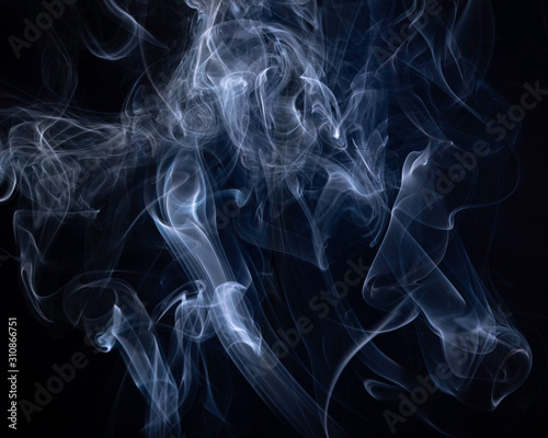 A close up macro photo of incense smoke lit by a blue flash to create a moody glow overlay