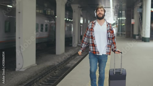 Portrait of a happy young man waiting for train at station