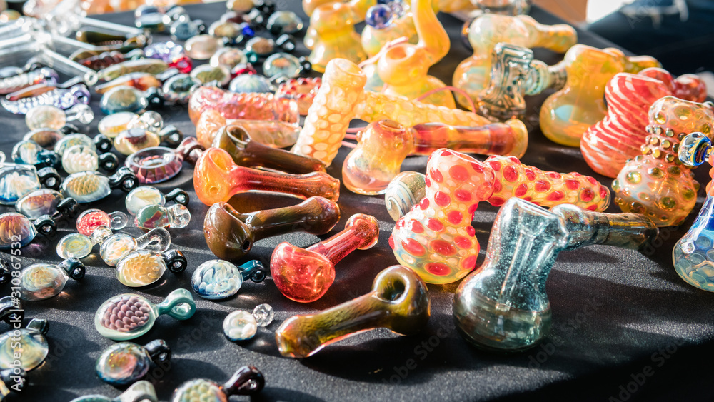 Accessories for smoking marijuana in the store, close-up. Glass bongs and smoking pipes.