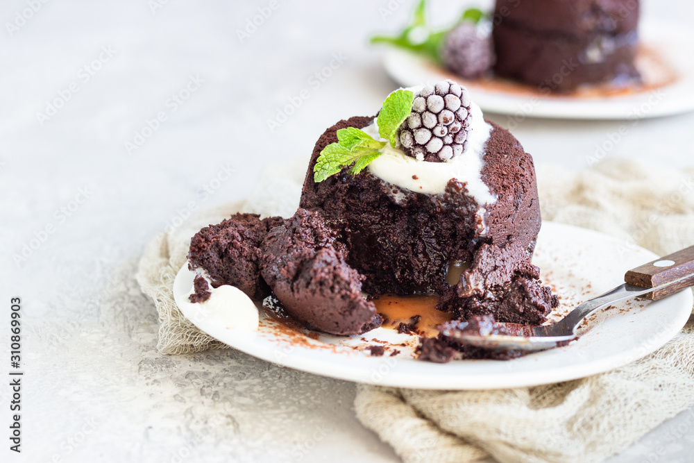 Warm dessert chocolate fondant with ice cream, mint and blackberry on the white plate. Lava cake recipe. Perfect dessert for Valentine’s Day. Warm dessert chocolate fondant with ice cream, mint and blackberry on the white plate. Lava cake recipe. Perfect dessert for Valentine’s Day.