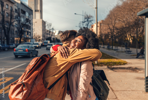 Smiling couple enjoying on vacation, young tourist having fun walking and exploring city street during the day.