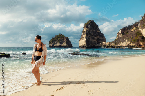 Woman walking on a beach at Diamond Bay, Nusa Penida island, Indonesia