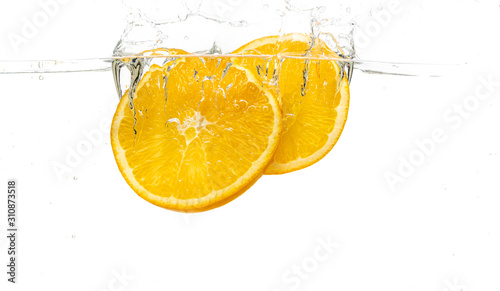 whole orange and tangerine and sliced slices falls under water