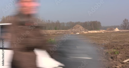roadway excavation - scraped topsoil  - wide shot. redirected traffic in foreground