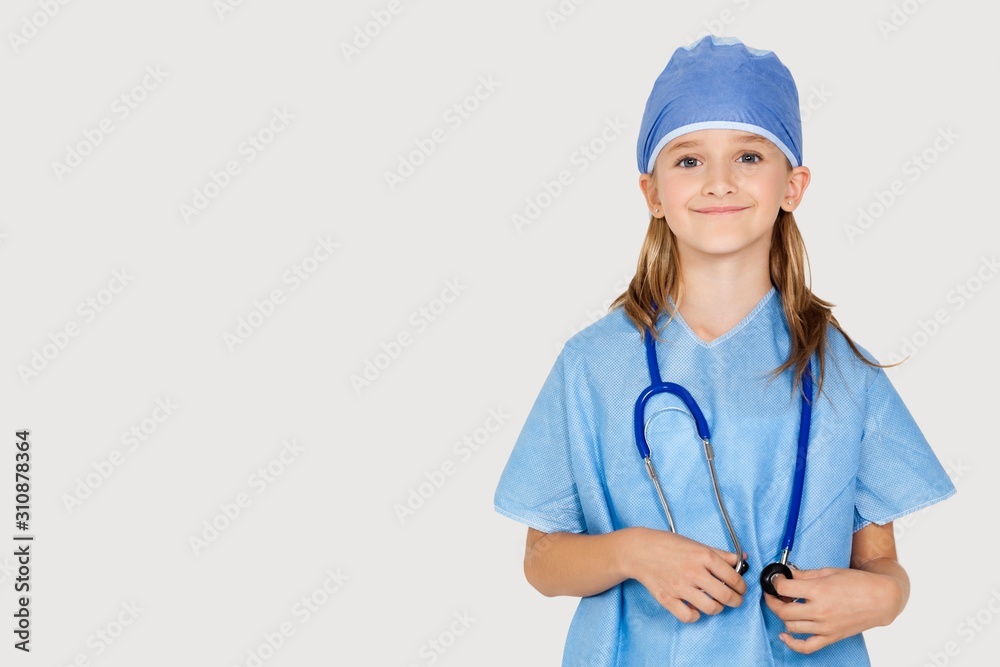 Portrait of young girl in surgeon's costume against gray background Portrait of young girl in surgeon's costume against gray background