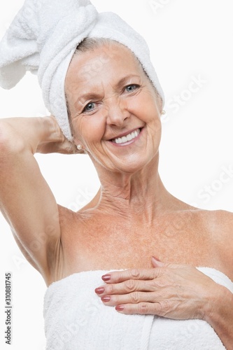 Portrait of senior woman wrapped in towels against white background