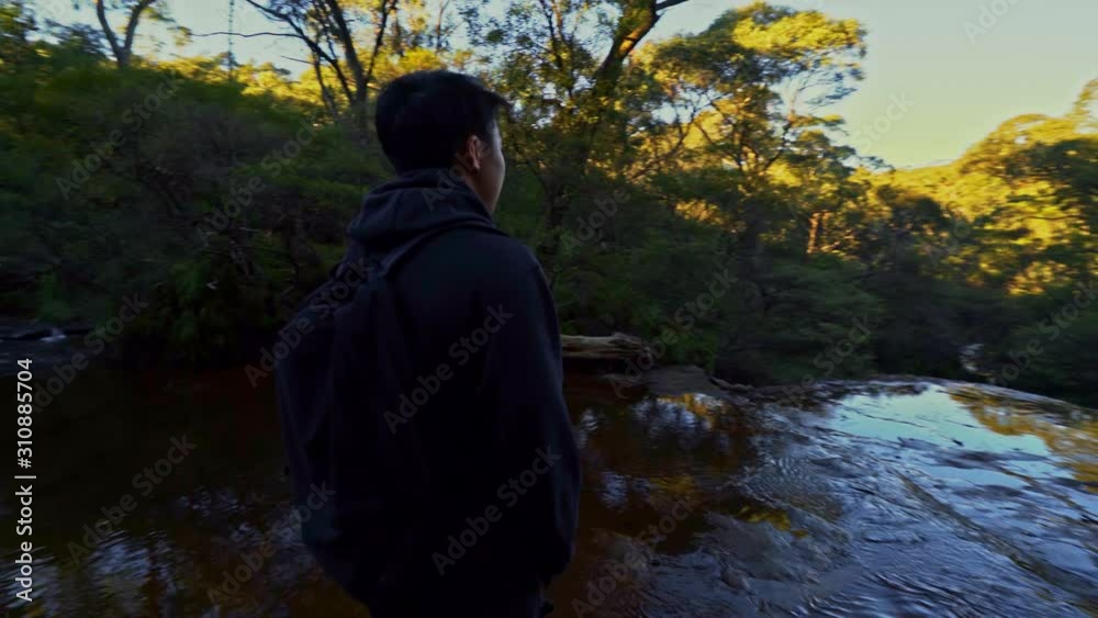 Asian man looks out over the Australian bush of the Blue Mountains National Park, Orbital shot. Asian man looks out over the Australian bush of the Blue Mountains National Park, Orbital shot.