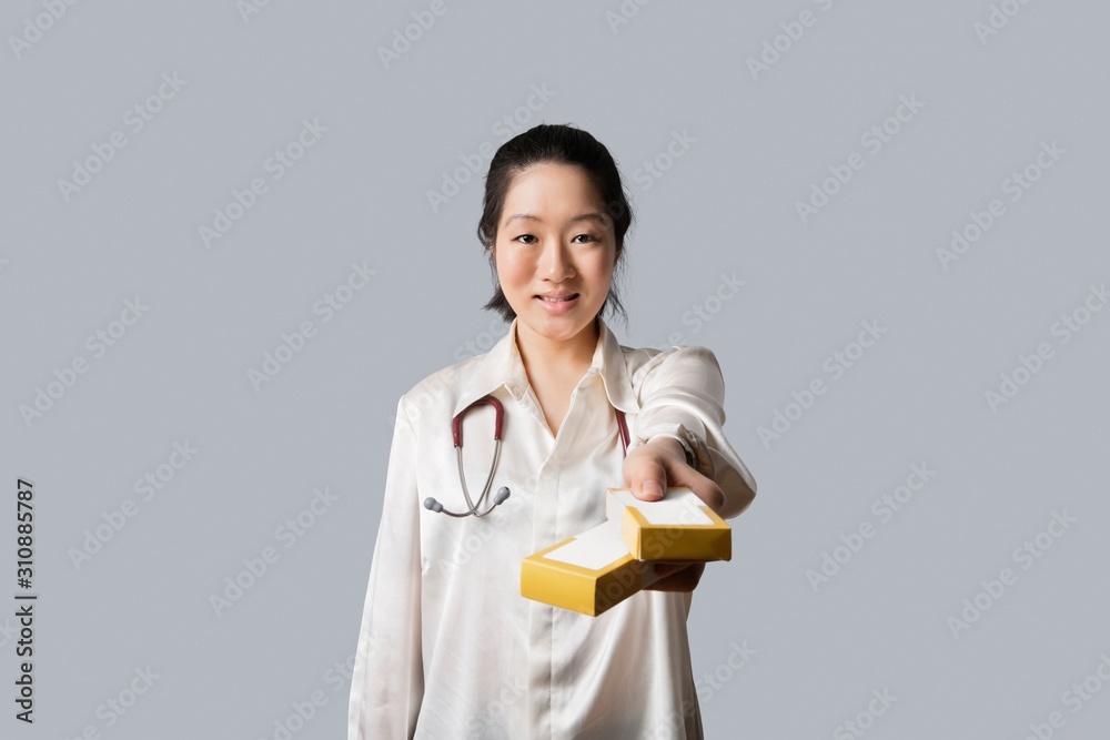 Portrait of a young female doctor giving medicine boxes Portrait of a young female doctor giving medicine boxes