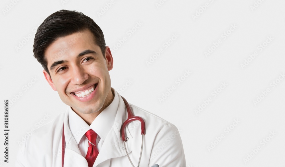 Cheerful Indian male doctor looking sideways over light gray background Cheerful Indian male doctor looking sideways over light gray background