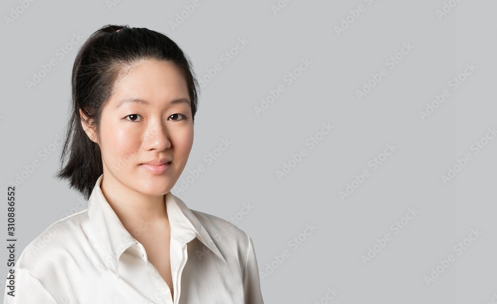 Portrait of a young Asian female doctor over gray background Portrait of a young Asian female doctor over gray background
