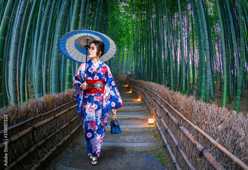 .Asian woman wearing Japanese kimono to visit bamboo forest in Kyoto, Japanใ