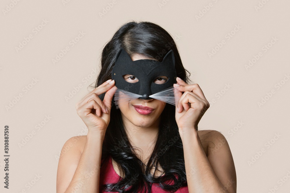Portrait of a young woman wearing eye mask over colored background Portrait of a young woman wearing eye mask over colored background