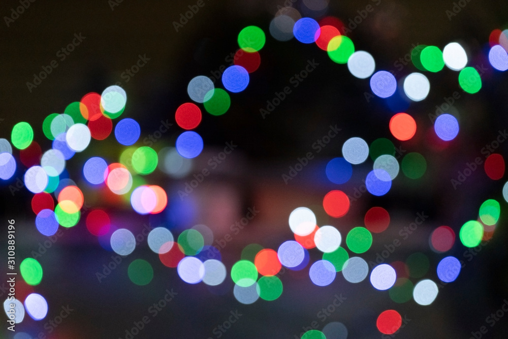 Abstract Christmas and New Year background with blur bokeh effect, holiday backdrop. Glitter rainbow Christmas festive lights