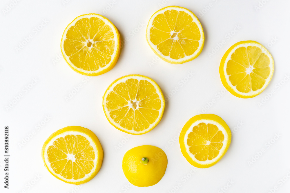 Lemon slices randomly lie on the light surface of the table.