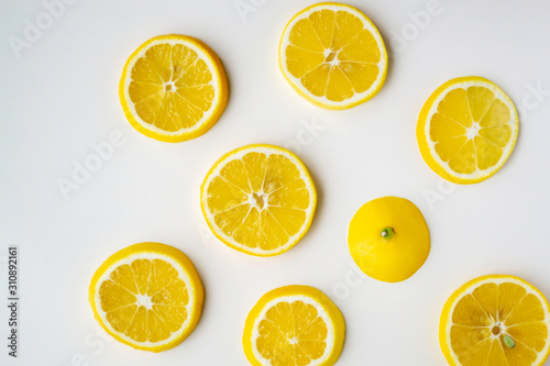 Lemon slices randomly lie on the light surface of the table.
