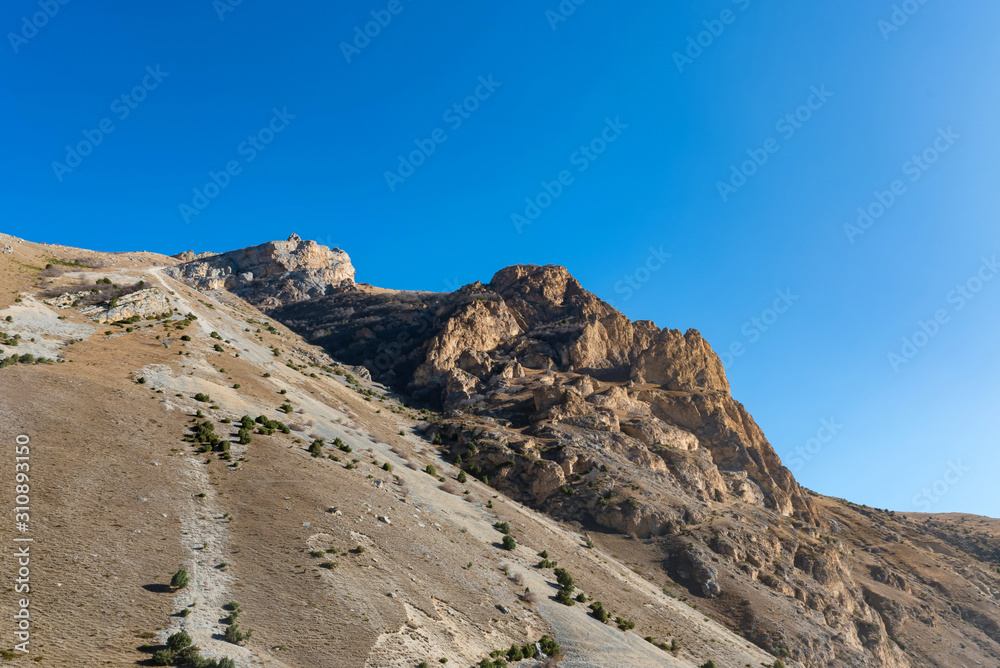 Rocks and dry grass in North Caucasus mountains in autumn on sunny day