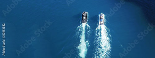 Aerial drone ultra wide photo of jet skis cruising in deep blue sea photo