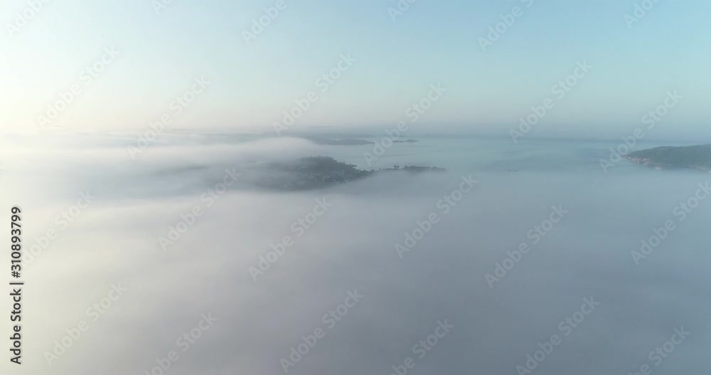 Aerial view of fog covering Kristiansand city in the morning during a sunrise. (Norway).