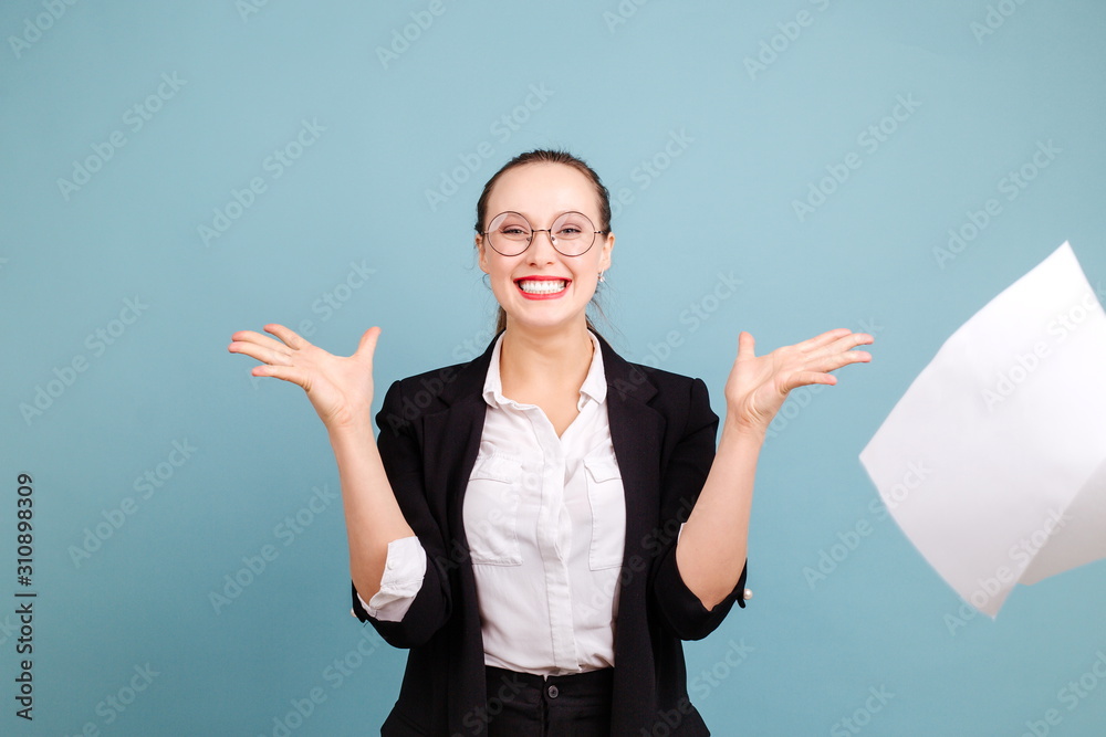 Beautiful girl with a beautiful smile in an office suit. Throws up sheets of paper enjoying the weekend Beautiful girl with a beautiful smile in an office suit. Throws up sheets of paper enjoying the weekend