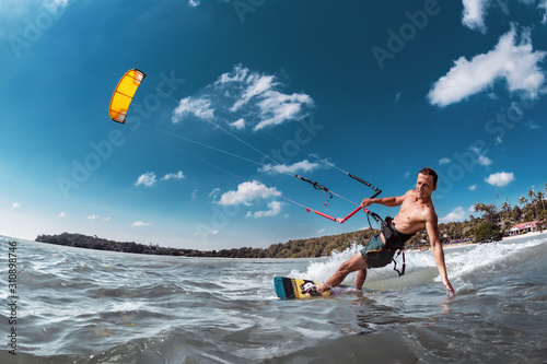 Real wakeboarder with kite at sea bay