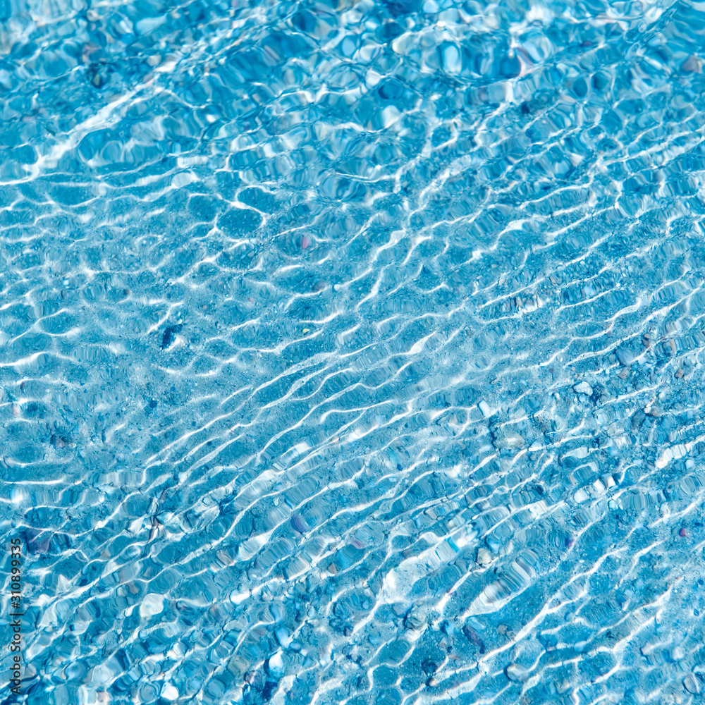 Obraz premium In the summer, the sun shines and the background of water waves flickers. The texture of the water.