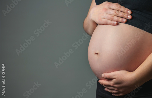 Unrecognizable pregnant woman caressing her belly