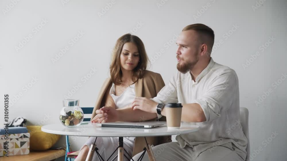 Attractive couple using laptop and talking in home Attractive couple using laptop and talking in home