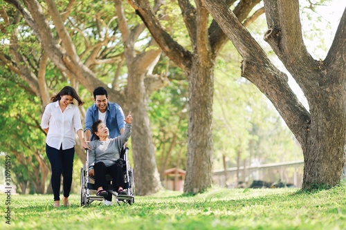 Elderly woman in wheelchair taking with her daughter and son in park © Mallika