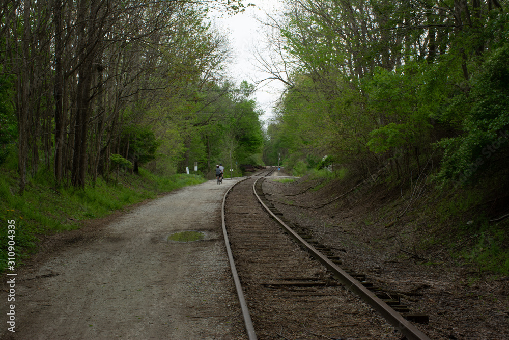 Bicyclist on path next to railroad tracks