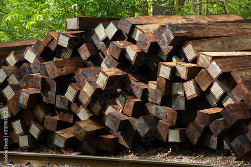 Railroad ties stacked next to tracks