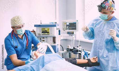 Several doctors surrounding patient on operation table during t