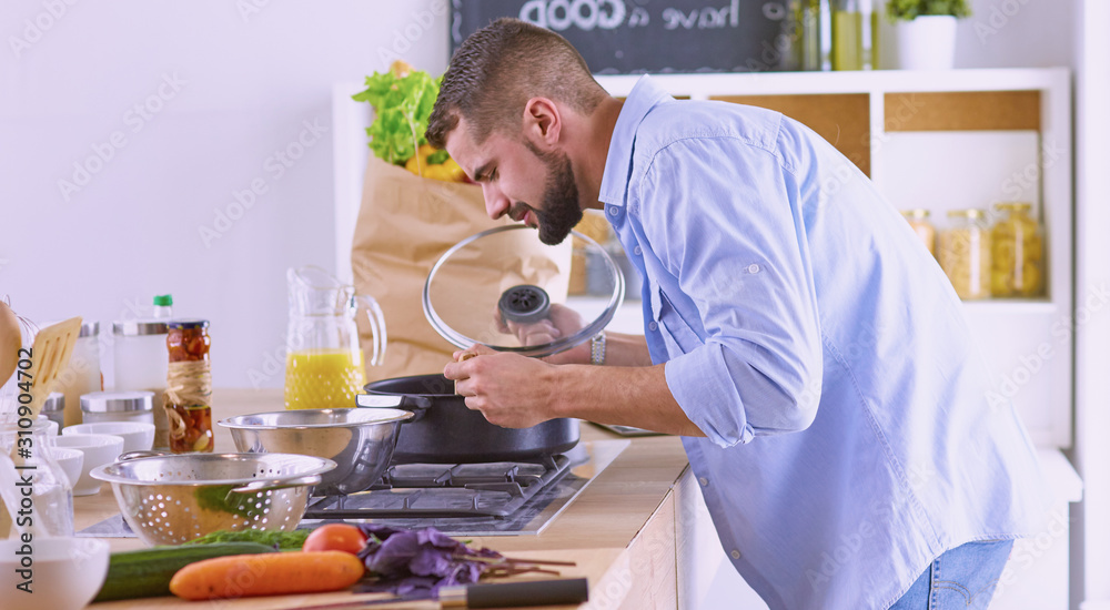 Smiling and confident chef standing in large kitchen Smiling and confident chef standing in large kitchen