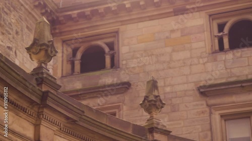 A panning shot from right to left of a closeup of a sandcoloured building photo