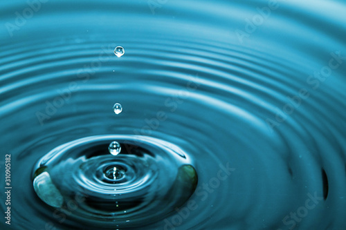 Closeup Water drop falling on the surface of the water and beautiful circular wave ripple  fresh natural mineral water drink water concept