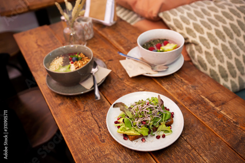 Healthy vegan bowls on wooden table in cozy café
