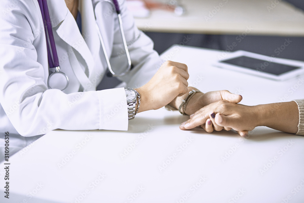 Obraz premium Woman doctor calms patient and holds hand