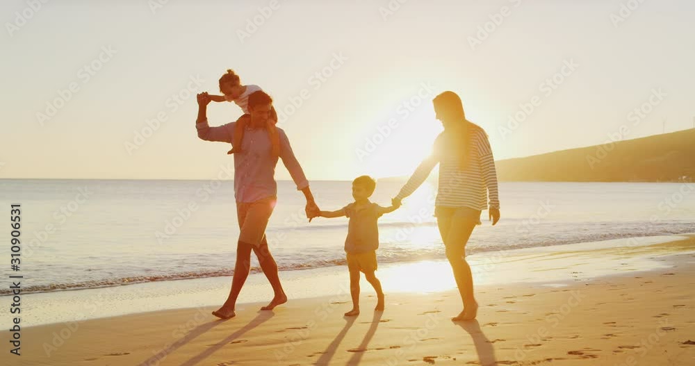 Two young toddler boys and their parents playing together happily on the beach at sunset, smiling parents walking with their children, riding on dad's shoulders, happy family on vacation Two young toddler boys and their parents playing together happily on the beach at sunset, smiling parents walking with their children, riding on dad's shoulders, happy family on vacation