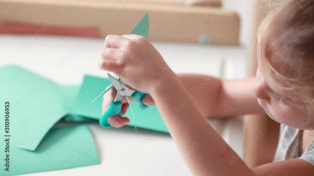 Little girl cuts out a cardboard flag for decoration. Little girl cuts out a cardboard flag for decoration.