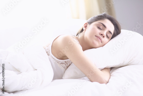 beautiful young woman basking in bed in the morning. Beautiful