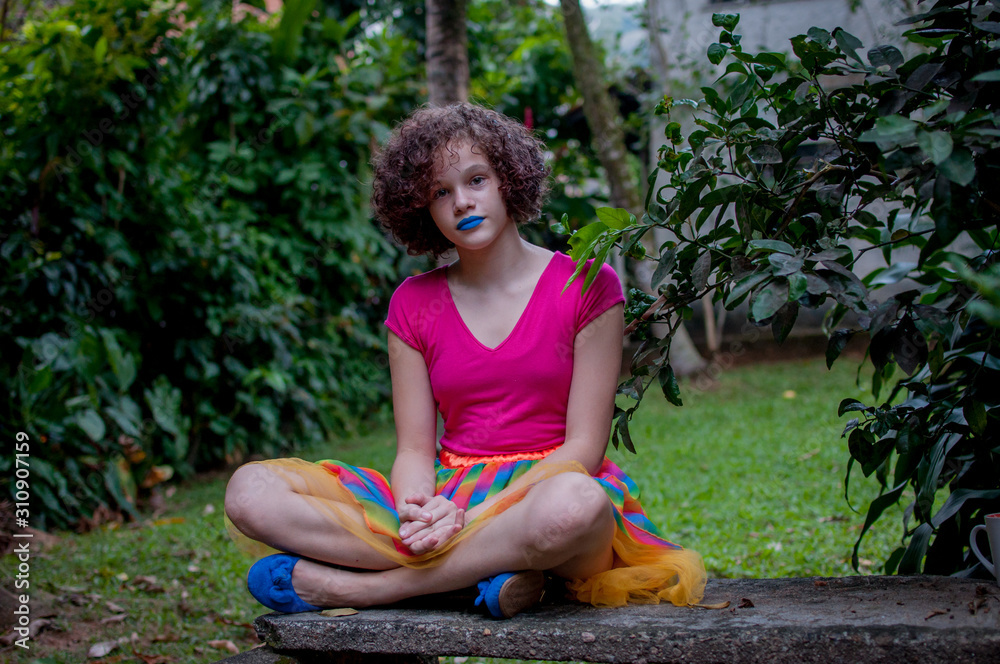 Naklejka premium Girl with blue lipstick sitting on the bench