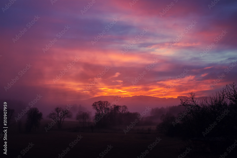 sunset in the mountains - red sky above hilly landscape