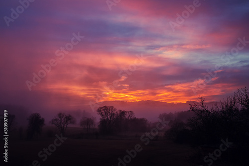 sunset in the mountains - red sky above hilly landscape
