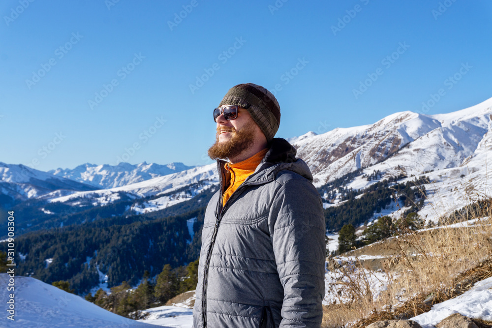 Young man tourist on mountains and forest background.
