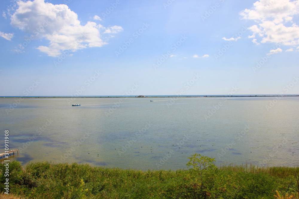 The nature landscape of sea, grass, sand, sky and clouds