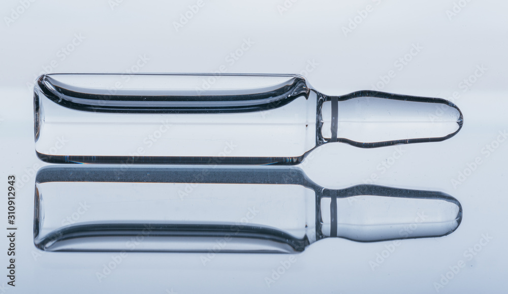 Glass medical ampoule vial for injection. Medicine is dry white drug penicillin powder or liquid with of aqueous solution in ampulla. Close up. Bottles ampule with aluminum cap on backgrounds gray. Glass medical ampoule vial for injection. Medicine is dry white drug penicillin powder or liquid with of aqueous solution in ampulla. Close up. Bottles ampule with aluminum cap on backgrounds gray.