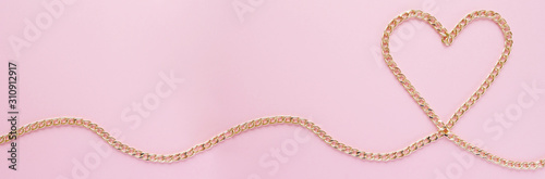 Wallpaper Mural a gold chain laid out in the shape of a heart on a pink background Torontodigital.ca