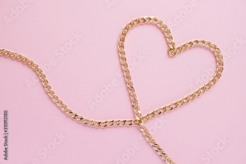 Wallpaper Mural a gold chain laid out in the shape of a heart on a pink background Torontodigital.ca