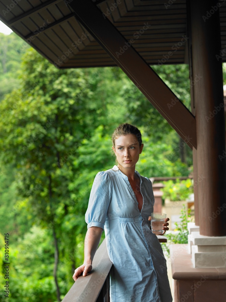 Woman In Veranda With Glass Of Water Woman In Veranda With Glass Of Water