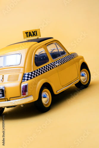 Yellow retro toy taxi on yellow background