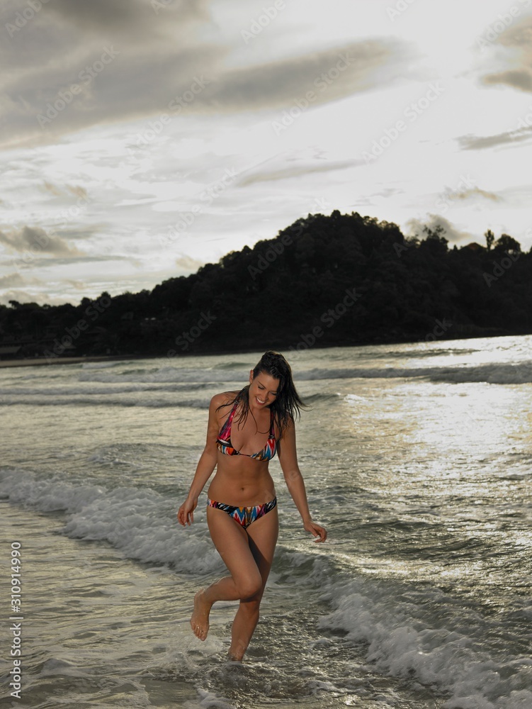 Naklejka premium Bikini Woman Walking In Water At Beach